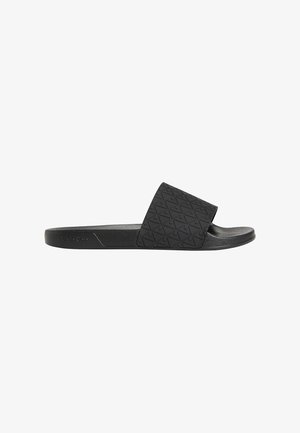 Schwarze Slip-On-Sandale mit strukturiertem geometrischem Muster auf breitem Riemen und gepolsterter Sohle, Seitenansicht vor weißem Hintergrund.