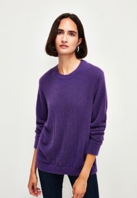 Lila Pullover aus weichem, strukturiertem Material. Mit einem runden Ausschnitt und langen Ärmeln, lockerer Passform und geripptem Saum.