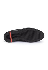 Suola di scarpa in gomma nera con motivo testurizzato, caratterizzata da una striscia di accento rossa vicino al tallone e un design liscio e curvo per il comfort.