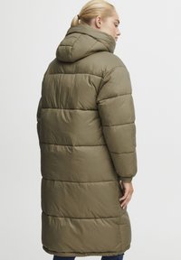 Manteau matelassé vert olive avec capuche, présentant un design quilté, des manches longues et des poches latérales. Matériau lisse et brillant avec une coupe décontractée.