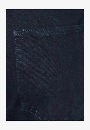 Dark blue denim fabric featuring a plain back pocket. The texture is smooth with a slight sheen and subtle diagonal weaving pattern.