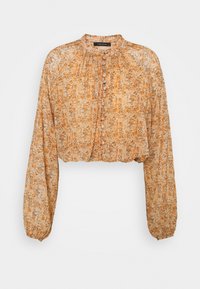 Blusa recortada en tejido ligero con estampado floral en tonos naranja y beige, de mangas largas, cuello alto y cierre frontal de botones.