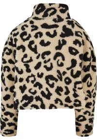 Giacca in pelliccia sintetica con base beige e stampa maculata nera, collo alto e maniche lunghe; texture morbida e design cropped.