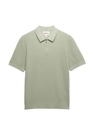Lysegrøn strikket polo med korte ærmer, ribbet tekstur og lynlås foran, lagt fladt mod en hvid baggrund.