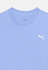 Ανοιχτό μπλε T-shirt με στρογγυλή λαιμόκοψη και λευκό λογότυπο Puma κεντημένο στο αριστερό στήθος, καθώς και ένα μικρότερο γκρι λογότυπο Puma μέσα στον γιακά.