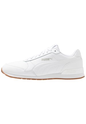 Baskets basses blanches Puma avec semelle en caoutchouc naturelle, lacets à l'avant et logo Puma sur le côté et le talon.