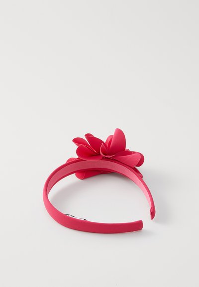 Bandeau rose avec une finition texturée, doté d'une grande fleur accent faite d'un matériau doux, renforçant son design ludique et sa couleur vive.