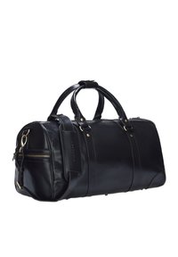 Czarna skórzana torba podróżna o zaokrąglonym kształcie, z podwójnymi uchwytami, regulowanym paskiem na ramię, złotymi elementami i zewnętrzną kieszenią na zamek.