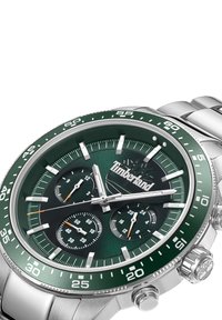 Orologio in acciaio inossidabile argentato con quadrante verde scuro, sotto-quadranti per il tracciamento del tempo e una lunetta verde con indicatori delle ore bianchi.
