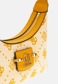 Borsa a tracolla gialla in tessuto con superficie decorata, dotata di una placca logo in metallo dorato e chiusura con cerniera.