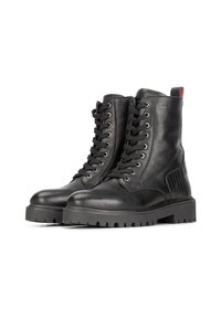 Botas de cuero negras hasta el tobillo con suela robusta, que cuentan con un diseño de cordones, panel lateral texturizado y una pestaña trasera para tirar. Tacón plano y acabado brillante.