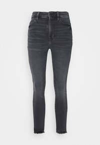 High-waisted black denim jeans with a fitted silhouette and distressed hems, featuring minimal fading and standard five-pocket design.