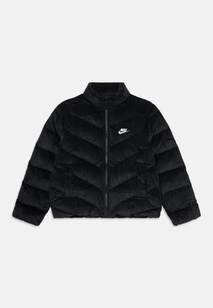 Veste matelassée en velours côtelé noire avec un col haut, fermeture éclair à l'avant et surpiqûres en chevron. Présente un petit logo Nike blanc sur la poitrine.