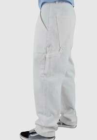 Pantaloni cargo bianchi con una vestibilità rilassata, caratterizzati da numerose tasche utilitarie, una silhouette leggermente ampia e cuciture rinforzate.