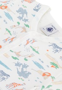 Λευκό βαμβακερό βρεφικό φορμάκι με πολύχρωμες ζωικές εκτυπώσεις, όπως καμηλοπαρδάλεις, λιοντάρια και ελέφαντες, με κούμπωμα με τριψήφιους κόμπους στο μπροστινό μέρος και στον λαιμό.