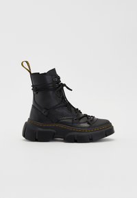Black ankle boots with a chunky sole, textured leather, round toe, and yellow stitching. Features a lace-up front and looped pull tab.