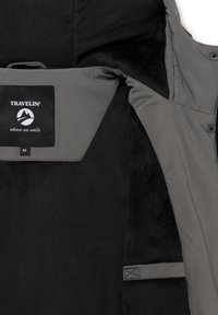 Grå jacka med en mjuk svart foder; har en logotyp-patch, en storleksetikett och knäppningar. Texturerad tyger, praktisk design.