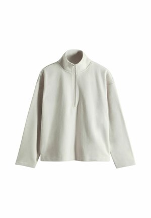 Pull en maille léger gris clair à manches longues, avec un col montant et une fermeture éclair moitié. Le tissu semble doux avec une texture lisse et une coupe légèrement décontractée.