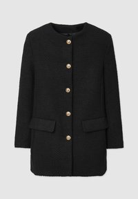 Cappotto nero texturizzato con scollo rotondo, dotato di bottoni dorati e due tasche frontali. Taglio dritto con un design di lunghezza media.