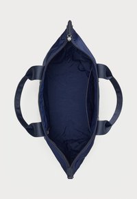 Laikina tamsiai mėlyna rankinė su minkštu audiniu išorėje, plačiu atidarymu, dviem rankenomis ir užtrauktuku viršuje. Vidus lygus ir be pamušalo.