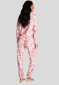 Langslang, bloemenpatroon loungset in roze en oranje tinten, met een relaxte pasvorm en elastische manchetten op de broek.