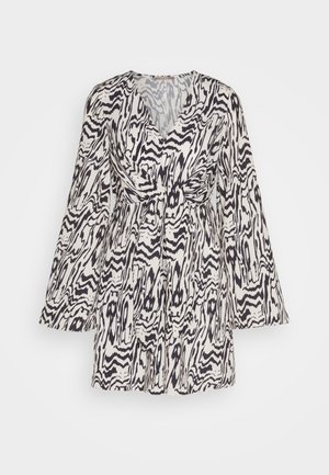 Floral print dress in white and black, featuring long bell sleeves and a cinched waist, V-neckline, and a flowing skirt with textured fabric.