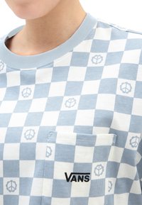 Sininen ja valkoinen ruudullinen t-paita, joka on valmistettu puuvillasta. Siinä on rintatasku ja musta "VANS"-logo. Pehmeä pinta, jossa on rauhan symbolien kuvioita.