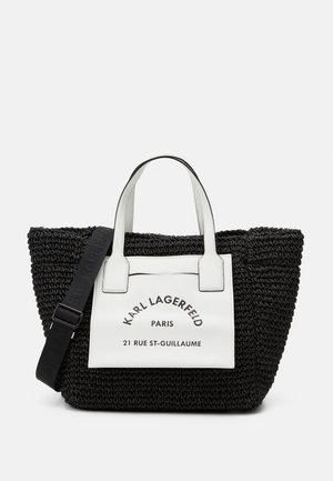 Black woven tote bag with white faux leather accents. Features a front label with "Karl Lagerfeld, Paris," and removable strap.