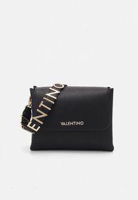 Svart läderväska att bära över axeln med vikbar design, utrustad med en guldfärgad "VALENTINO"-logoband och texturerad yta. Platt, rektangulär form.