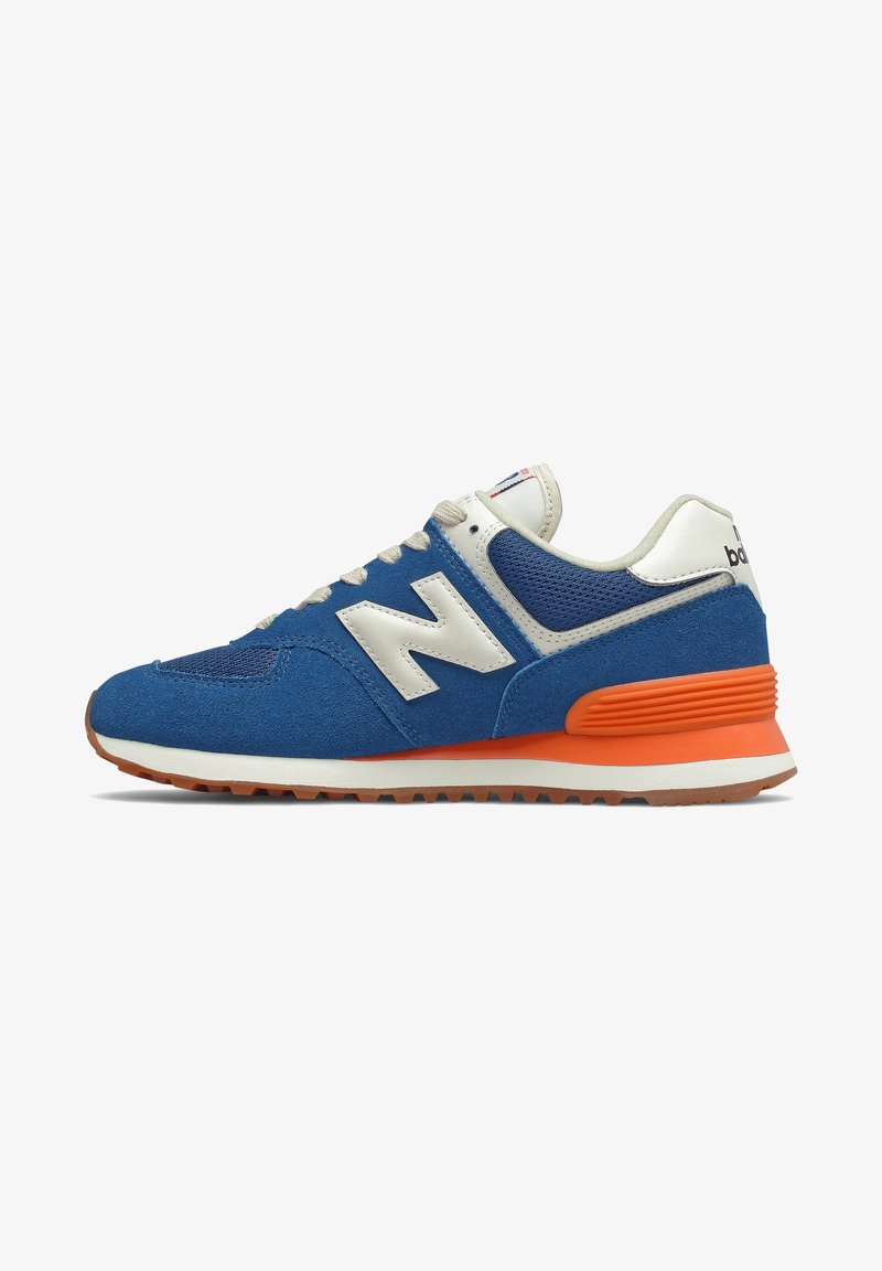 Blauwe en witte New Balance sneaker met een oranje tussenzool, bovenwerk van suède en mesh, witte veters en rubberen zool, getoond vanuit de zijkant.