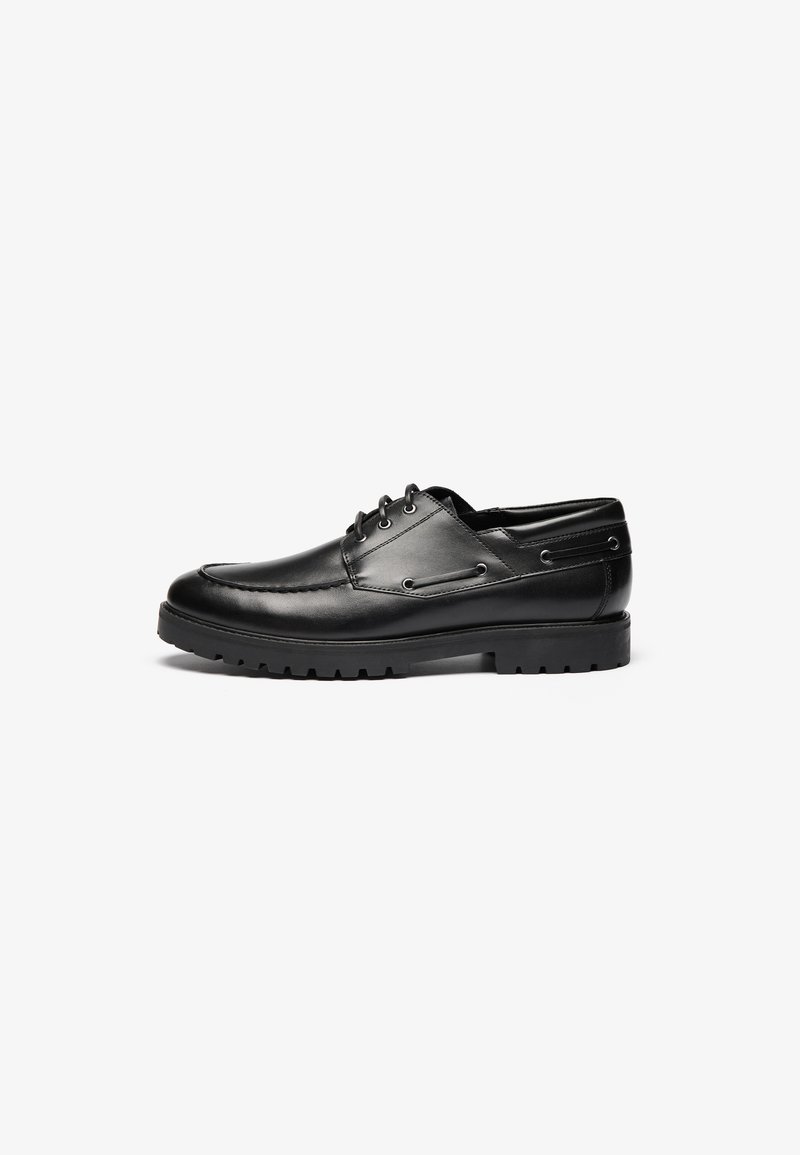 Black leather lace-up shoes with a rounded toe, decorative stitching, and a durable rubber sole featuring deep treads for traction.