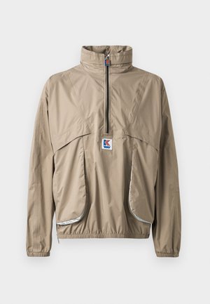 Veste à capuche beige avec un zip quart sur le devant, des poignets élastiques et deux grandes poches avant, comportant un petit logo sur la poitrine.