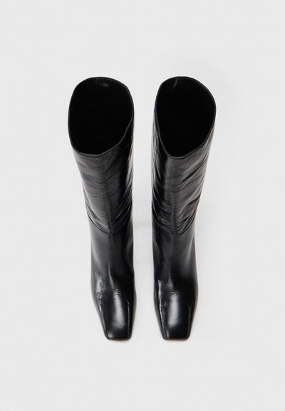 Fekete bőr, térdig érő csizmák négyzet formájú orral, sima textúrával és letisztult, minimalistikus dizájnnal.