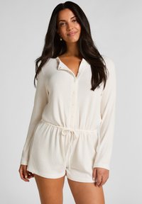 Mono blanco acanalado con mangas largas, escote tipo henley abotonado, cintura elástica y detalle de cordón. Tejido suave con acabado texturizado.