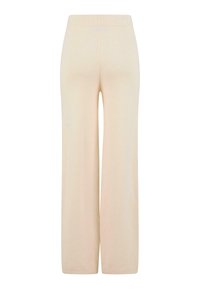 Beżowe spodnie o szerokich nogawkach z elastycznym paskiem w talii, wykonane z miękkiego materiału, charakteryzujące się gładką fakturą i brakiem widocznych wzorów lub elementów metalowych.