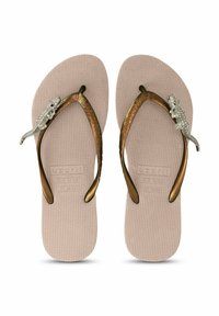 Des tongs marron avec des semelles beige texturées, ornées d'un accent en argent représentant un lézard sur les lanières. Design plat, style décontracté.