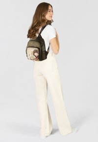 Rucksack aus dunklem, strukturiertem Material mit einer verspielten Grafik eines Mädchens. Die Tasche verfügt über verstellbare Riemen und einen Reißverschluss.