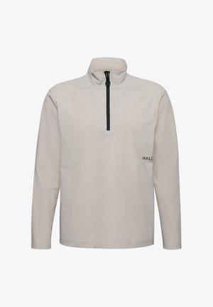 Jasno beżowy pulower z długim rękawem i zamkiem na suwak. Posiada czarny zamek błyskawiczny oraz małe czarne logo "HALO" na dolnej lewej stronie. Teksturowany materiał.