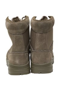 Pruuni sametist pahkluu saapad kangaspaneelidega, ümar varvas, pehmendatud krae ja kummist välistald, näidates külgedel õmblus detaile.