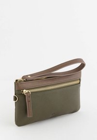 Clutch de cuero verde con cremallera superior marrón, herrajes dorados y una correa de muñeca desmontable. Superficie texturizada con acentos suaves.