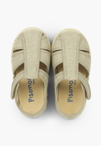 Beige sandaalit, joissa on tekstiilipinta, leikattu muotoilu, säädettävä hihna ja pehmeä pohja. Logo painettuna pohjalliseen. Kevyt rakenne.