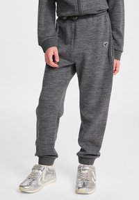 Graue Sweatpants aus weichem Material, mit elastischem Bund, Bündchen an den Knöcheln und einem kleinen gestickten Logo an der Seite.