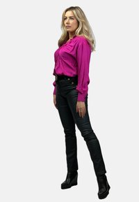Fuksjowa bluzka z bufkami, zestawiona z czarnymi spodniami z faux skóry o wysokim stanem oraz czarnymi botkami na obcasie. Proste metaliczne akcenty.