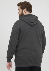 Sudadera gris oscura con capucha ajustable, mangas largas y un corte relajado. Fabricada con una suave tela texturizada y un diseño simple.