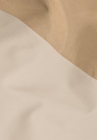 Tissu bicolore en beige clair et beige sable, avec une texture lisse. Le design comporte une couture diagonale où les deux couleurs se rencontrent.
