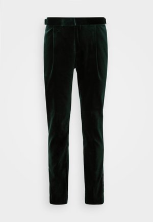 Sile rohelised sametpüksid, millel on sile tekstuur, kohandatud istuvus, kaks esist pleeku ning külgõmbluse detail.