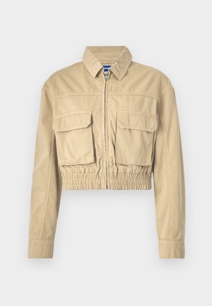 Cropped beige jacket made of cotton with a zip front, two chest pockets, elastic waist, and button cuffs. Smooth texture and lightweight design.