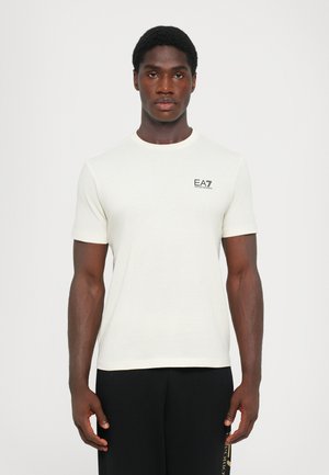 Hvit t-skjorte med korte ermer laget av et glatt stoff, med en liten svart EA7-logo på brystet og rund halsdesign.
