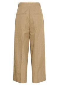 Beige leveled trousers dengan tekstur halus, memiliki pinggang tinggi, dua saku belakang, dan desain yang bersih serta minimalis.