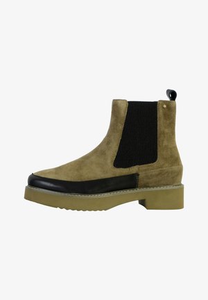 Stivale alla caviglia in suede marrone con pannelli elastici neri ai lati, punta in gomma nera e suola chunky beige. Presenta un'etichetta per il risvolto sul retro.